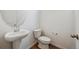 A powder room with a pedestal sink, modern faucet, and a white toilet at 24717 E 40Th Ave, Aurora, CO 80019