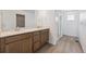 Bright bathroom featuring double sinks, wood cabinets, white countertops, and glass-enclosed shower at 24717 E 40Th Ave, Aurora, CO 80019