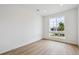 Bright, minimalist bedroom with a large window and modern, light-colored wood flooring at 24717 E 40Th Ave, Aurora, CO 80019