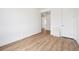 A clean, minimalist bedroom featuring light wood flooring and neutral walls, with doors at 24717 E 40Th Ave, Aurora, CO 80019