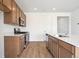 Modern kitchen featuring an island with a white countertop, stainless steel appliances and light wood flooring at 24717 E 40Th Ave, Aurora, CO 80019