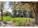 A backyard with a lush lawn, mature trees, a stone border and a covered patio is perfect for relaxing at 9479 S Shadow Hill Cir, Lone Tree, CO 80124