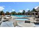 Community pool with lounge chairs, tables, a hot tub and umbrellas on a sunny day at 9479 S Shadow Hill Cir, Lone Tree, CO 80124