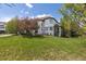 Stately home with a lush green lawn, complemented by mature trees and attractive architectural details at 9479 S Shadow Hill Cir, Lone Tree, CO 80124