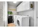 Laundry room with washer, dryer, and overhead cabinets at 340 S Swadley St, Lakewood, CO 80228
