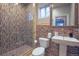 Modern bathroom features a tiled glass shower, decorative tiling, and a pedestal sink for a sleek, contemporary look at 6638 S Tibet Ct, Aurora, CO 80016