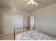 A cozy bedroom with neutral walls, white trim, and a floral patterned bedspread at 6638 S Tibet Ct, Aurora, CO 80016