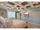 Bright main bedroom featuring tray ceilings, a ceiling fan, and comfortable window seat for relaxation at 6638 S Tibet Ct, Aurora, CO 80016