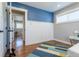 Inviting bedroom featuring stylish accent wall, trim, and well-maintained hardwood floors at 3461 S Ivy Way, Denver, CO 80222