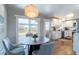 Inviting dining area open to kitchen with a modern chandelier and natural light at 3461 S Ivy Way, Denver, CO 80222