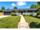 Inviting single-story home featuring a lush green lawn, sidewalk, and attractive landscaping at 3461 S Ivy Way, Denver, CO 80222