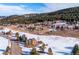 Aerial view of a two-story home nestled among mature trees with snow in the foreground at 9019 Armadillo Trl, Evergreen, CO 80439