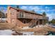 Back exterior view of the home featuring a brick chimney, wood siding, and stairs to the deck at 9019 Armadillo Trl, Evergreen, CO 80439