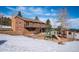 Backyard view with a wooden playset and shed in a partially snow-covered yard at 9019 Armadillo Trl, Evergreen, CO 80439