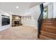 Cozy basement area with a stone fireplace, stairs, and a view outside the window at 9019 Armadillo Trl, Evergreen, CO 80439