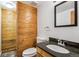 Bathroom with wood walls, a granite countertop sink, and a toilet at 9019 Armadillo Trl, Evergreen, CO 80439