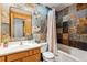 Bathroom featuring decorative tile in the shower, natural cabinets, and vanity at 9019 Armadillo Trl, Evergreen, CO 80439