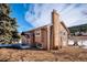 Exterior view of a home with a brick chimney and spacious yard at 9019 Armadillo Trl, Evergreen, CO 80439