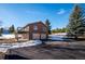 Two story home with a large deck above a two-car garage, surrounded by snowy landscaping at 9019 Armadillo Trl, Evergreen, CO 80439