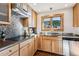 Bright kitchen features mosaic backsplash, stainless steel counters, and a view of the trees at 9019 Armadillo Trl, Evergreen, CO 80439