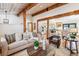 The bright living area flows into a spacious kitchen and dining area with wood-beam accents at 9019 Armadillo Trl, Evergreen, CO 80439