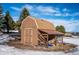 A shed with wood storage, featuring wood siding and a lean-to roof at 9019 Armadillo Trl, Evergreen, CO 80439