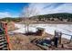 Backyard view from the deck with a shed, play set, and partially snow-covered landscape at 9019 Armadillo Trl, Evergreen, CO 80439