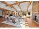 Spacious living room with wooden beams, a stone fireplace, and access to an outdoor view at 1420 Sierra Dr, Boulder, CO 80302