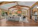 Expansive living room with stone fireplace, wooden beams, and access to outdoor space at 1420 Sierra Dr, Boulder, CO 80302