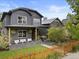 Charming home exterior with a welcoming front porch, swing, manicured lawn, and a stylish wooden fence at 2533 N Emerson St, Denver, CO 80205