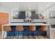 Modern kitchen features an island with seating, stainless steel appliances, and stylish pendant lighting at 2533 N Emerson St, Denver, CO 80205
