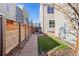 Narrow backyard with a stone paver walkway, small patch of grass, and a wood fence at 5438 Valentia St, Denver, CO 80238