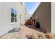 Narrow backyard with a stone paver patio and walkway and a partial wood fence at 5438 Valentia St, Denver, CO 80238