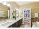 Bathroom with double vanity, white countertops, modern fixtures, and an adjacent bedroom at 5438 Valentia St, Denver, CO 80238