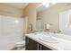 Bathroom with a single sink vanity, standard tub and shower, and a framed mirror at 5438 Valentia St, Denver, CO 80238