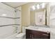 Bathroom with shower-tub combo, mosaic tile accent, and a single vanity at 5438 Valentia St, Denver, CO 80238