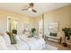 Cozy bedroom features white bedding, neutral walls, stylish decor, and a ceiling fan at 5438 Valentia St, Denver, CO 80238