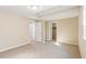 Empty bedroom with neutral carpet and paint, two doorways, and a small window at 5438 Valentia St, Denver, CO 80238