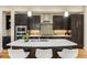 Modern kitchen island complete with white counter tops, stainless steel appliances, and dark cabinets at 5438 Valentia St, Denver, CO 80238