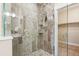 Walk-in shower featuring decorative tile, rainfall shower head, and built-in shelves at 5438 Valentia St, Denver, CO 80238