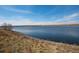 Beautiful lake view showcases serene waters and lush grassy banks, creating a peaceful ambiance at 1424 Swan Ave, Brighton, CO 80601