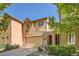 Inviting tan home with a beige two-car garage, an arched entry, and landscaped front yard at 11839 E Maplewood Ave, Greenwood Village, CO 80111
