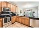 Open kitchen with stainless steel appliances, ample cabinet space, and a view of the dining area at 11839 E Maplewood Ave, Greenwood Village, CO 80111