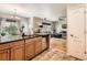 Open kitchen with wood cabinets, stainless steel appliances, and view into the adjacent living room at 11839 E Maplewood Ave, Greenwood Village, CO 80111