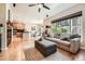 Bright living room featuring hardwood floors, a ceiling fan, and views into the kitchen and dining area at 11839 E Maplewood Ave, Greenwood Village, CO 80111