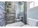 Modern shower with gray wood-look tile, glass doors, and stylish fixtures at 11839 E Maplewood Ave, Greenwood Village, CO 80111