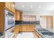 Bright kitchen with stainless steel appliances and wood cabinets at 154 Cisne Cir, Brighton, CO 80601