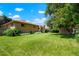 Large backyard with greenery, grass, and mature trees creating a private outdoor space at 1803 Graves Ct, Northglenn, CO 80233