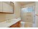 Bathroom featuring a tiled shower, glass doors, single sink vanity, and white toilet at 1803 Graves Ct, Northglenn, CO 80233