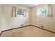 Cozy bedroom with neutral carpet, white walls, and two windows offering natural light at 1803 Graves Ct, Northglenn, CO 80233